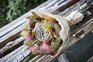 Bunch of rotten fruit and wilted flowers lay on old wooden boards