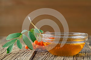 Bunch of rowan berries and bowl of honey