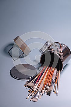 A Bunch of Rustic Artist Brushes in a Metal Bucket