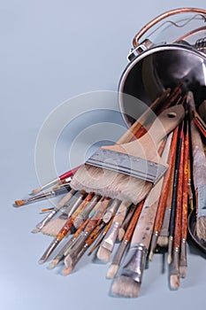 A Bunch of Rustic Artist Brushes in a Metal Bucket