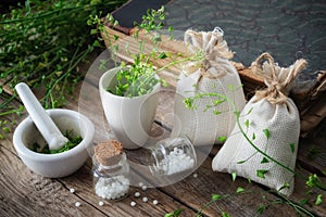 Bunch of shepherds purse, homeopathic bottle, mortar and old book.