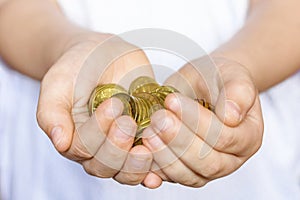 A bunch of small coins in the hands of a little boy