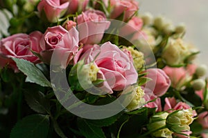 Bunch of small pink and yellow small roses on brick background