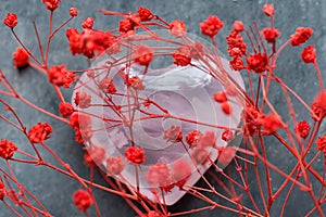 Bunch of Small Red Delicate Flowers Heart Shape Pink Quartz Crystal Sugar Candy Sprinkles on Grey Background. Romantic Valentines