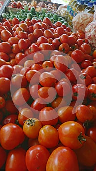 a bunch of small red tomatoes at a traditional market