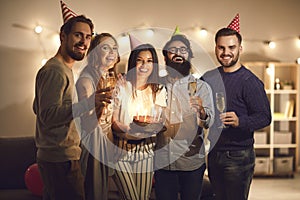 Bunch of smiling friends standing close to each other for group photo at birthday party at home