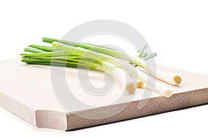 Bunch of spring onions on a wooden plate or board