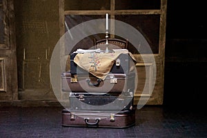 bunch of suitcases on a theater stage with candles in a candlestick