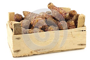 Bunch of topinambur roots (helianthus tuberosus) in a wooden crate