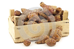 Bunch of topinambur roots (helianthus tuberosus) in a wooden crate