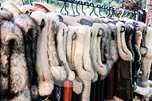 A bunch of traditional Ukrainian fur vests hanging for sale in an outdoor store in a rural village in Ukraine. Handmade