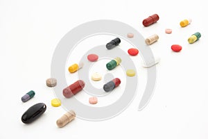 Bunch of variously colored generic medical pills and capsules arranged in rows isolated on white