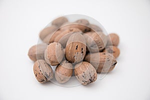 Bunch of wallnuts still in shells lying against white background