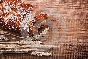 Bunch of wheat ears crusty roll on oak wooden