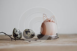 Bunch of white eggs with willow branch and bunny ears on wood background