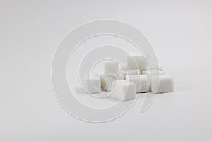 Bunch of white sugar cubes on light background