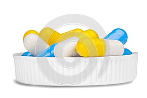 Bunch of yellow and blue pills in white medical cover