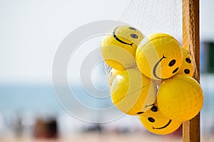 The bunch of Yellow-colored Stress reliever and hand exercise smiley balls on the beach.