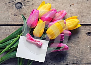 Bunch of yellow and pink spring tulips and vempty tag on vinta