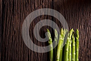 Bunches of asparagus on a wood background.