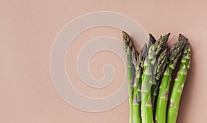 Bunches of fresh green asparagus on beige table top view