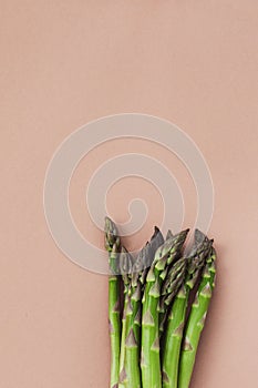 Bunches of fresh green asparagus on beige table top view