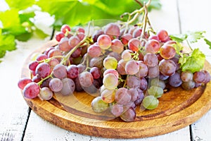 Bunches of fresh red grapes on a white wooden table