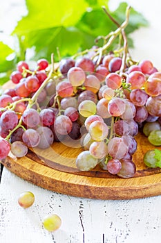 Bunches of fresh red grapes on a white wooden table