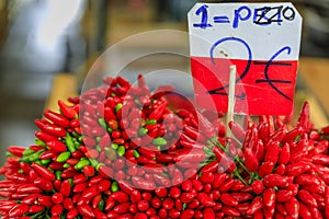 Bunches of red chili pepper ristras on display at a farmer's market in Venice by the canals with a price tag