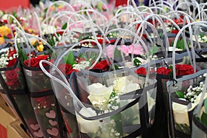 Bunches of , roses in handled  bags in red, pink, white,  and yellow for Valentine`s Day Sale Hundreds of flowers