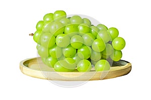 Bunches Shine Muscat grapes placed on wooden plate isolated on white background with clipping path. Closeup side view