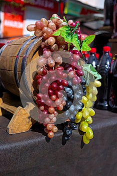 Bunches of white, pink and dark grapes on an old wooden wine barrel.