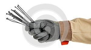 Bundle of black plastic cable ties in electrician hand in black protective glove and brown uniform isolated on white background
