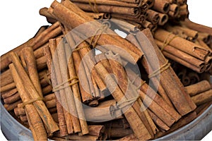 Bundle of cinnamon stick in basket isolated on white. healthy spice, (Cinnamomum