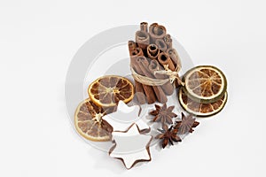 Bundle of cinnamon sticks staranises dried orange slices christmas pastries on white background