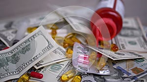 Bundle of Dollar Bills Falls on Table with Money, Pills. Rising Cost Healthcare