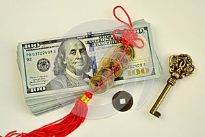 A bundle of 100 dollar bills  a key  and chinese coins talismans to attract wealth and success photo