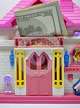 A bundle of dollars on a dollhouse