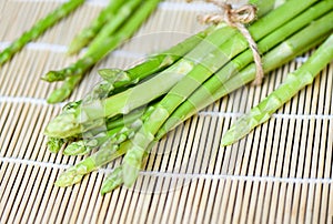 Bundle of fresh green asparagus on a rustic wooden table, asparagus bunch for cooked food