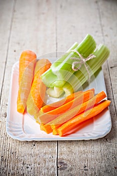 Bundle of fresh green celery stems and carrot