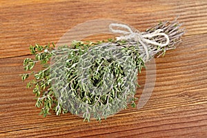 Bundle of fresh thymes on a wooden background