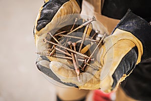 Bundle Of Golden Screws In Man`s Hands