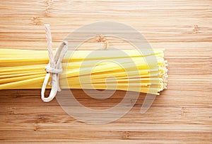 Bundle of Italian spaghetti pasta tied with string lying on old