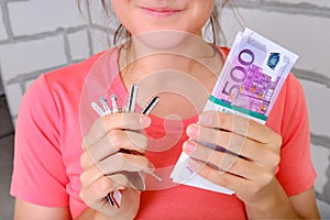 A bundle of money in the hands of the girl on the background of the empty rooms in the constructed flat. Satisfied woman holding