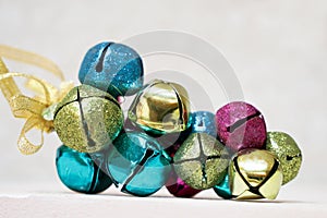 Bundle of multicolored shiny jingle bell on a solid background