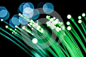 Bundle of optical fibers with green light. Black background