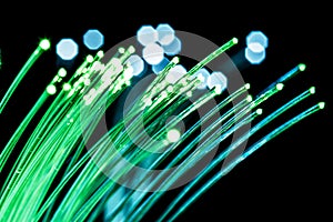 Bundle of optical fibers with green light. Black background