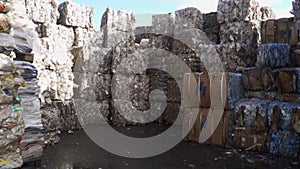 Bundle of pressed plastic bottles prepared for a garbage recycling on waste recycling plant. Camera moves forward