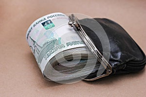 A bundle of Russian banknotes of 1000 rubles in an old black wallet