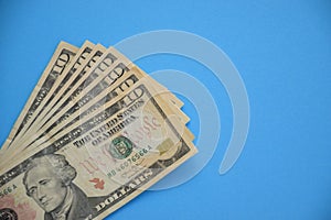 Bundle of ten dollar bills banknotes on blue background